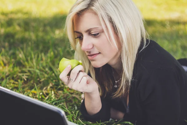Student tjej med laptop studerar i park — Stockfoto