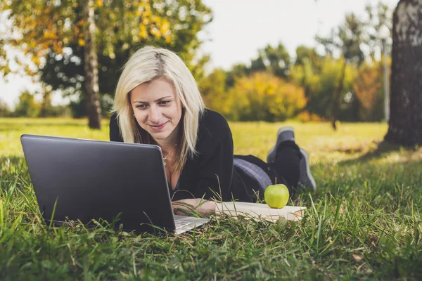 Studente ragazza con computer portatile che studia nel parco — Foto Stock