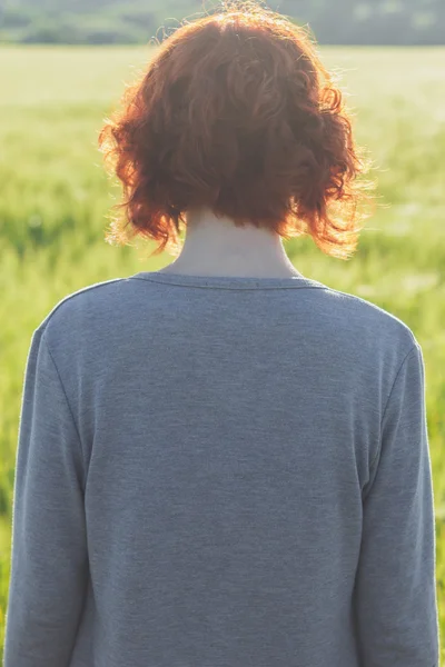 Meisje en groen veld in de ochtend — Stockfoto