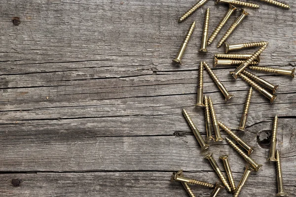 Yellow screws on the wooden table — Stock Photo, Image