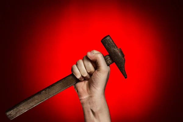 Mann hält Hammer über Rot — Stockfoto