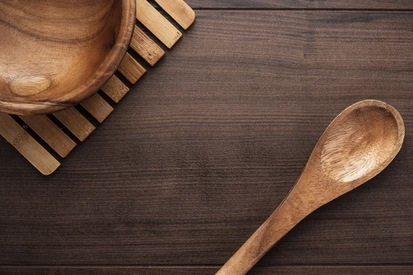 Wooden salad plate and spoon on brown table — Stock Photo, Image