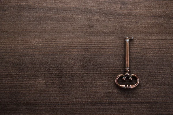 Oude messing sleutel op houten tafel — Stockfoto