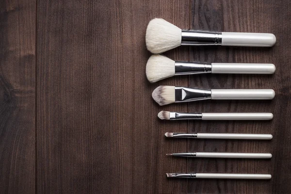 White make-up brushes on wooden table — Stock Photo, Image