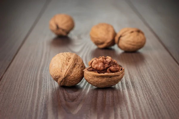 Vlašské ořechy na hnědý dřevěný stůl — Stock fotografie