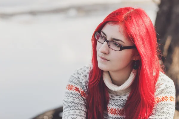 Roodharige vrouw zitten in de buurt van de rivier — Stockfoto