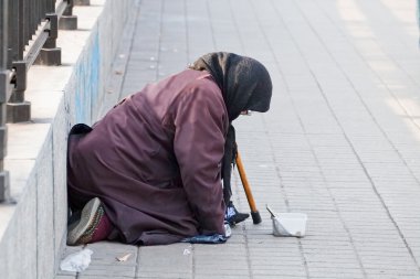 Zavallı yaşlı kadın bir sadaka yalvarıyor.