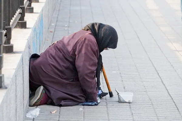 A pobre mulher velha implorando uma esmola . — Fotografia de Stock