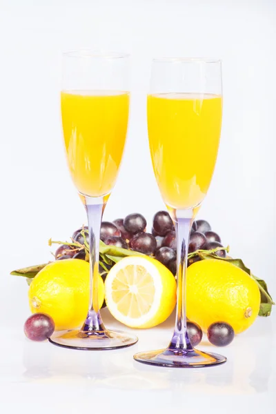 Lemon, gelas anggur dengan jus dan anggur — Stok Foto