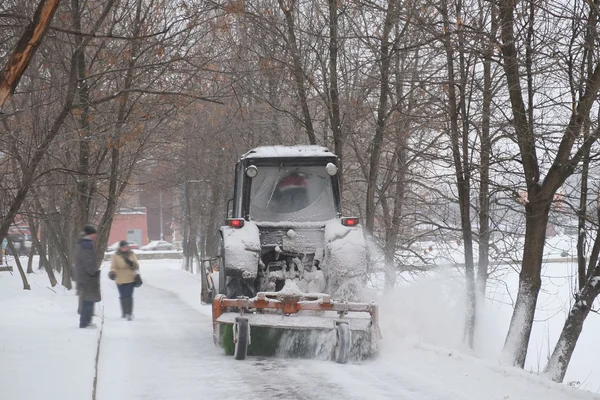 Snow-removal tractor cleans alley in the park — Stock Photo, Image