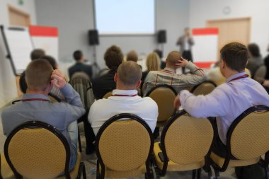 seyirci bir konferans salonunda dinler