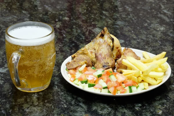Meat with garnish and mug of beer — Stock Photo, Image