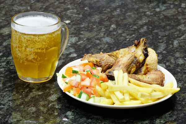 Meat with garnish and mug of beer — Stock Photo, Image