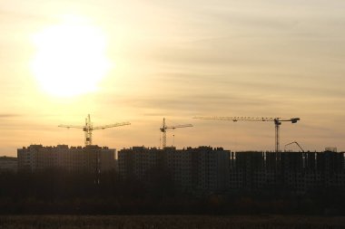 Günbatımındaki turnalar, Rusya 'nın Tula kenti yakınlarındaki modern resedential bölgesinin inşası üzerinde çalışıyorlar.