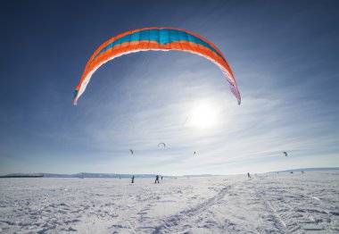 kiteboarder ile kar üzerinde mavi uçurtma