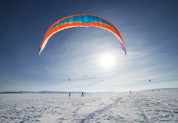 Kiteboarder com pipa azul na neve — Fotografia de Stock