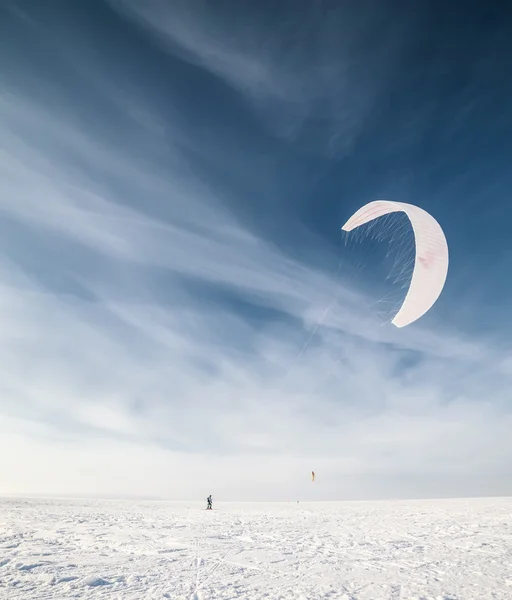 Kiteboarder avec cerf-volant bleu sur la neige — Photo