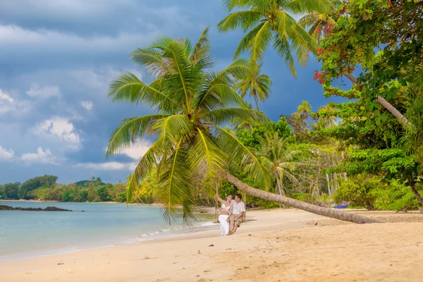 Coppia felice seduta sulla spiaggia soleggiata — Foto Stock