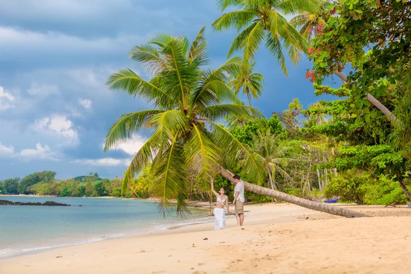 Happy couple sitting on the sunny beach — Stock Photo, Image