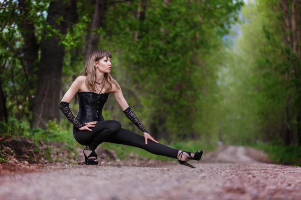 Beautiful elegant woman walking on a country road — Stock Photo, Image