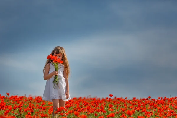 Niña en un campo de amapola — Foto de Stock