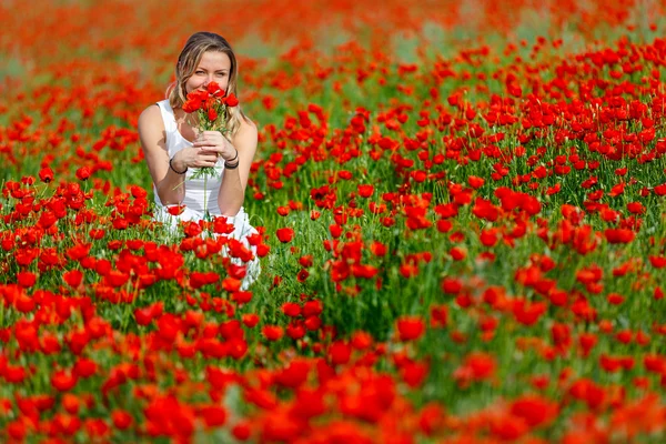 Chica en un vestido blanco en el campo de amapola — Foto de Stock