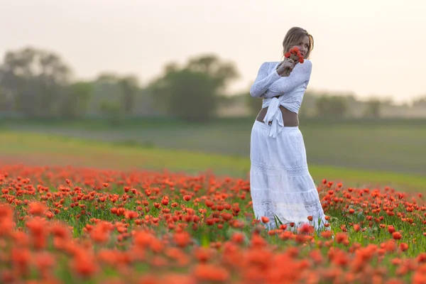 Chica en un vestido blanco en el campo de amapola — Foto de Stock