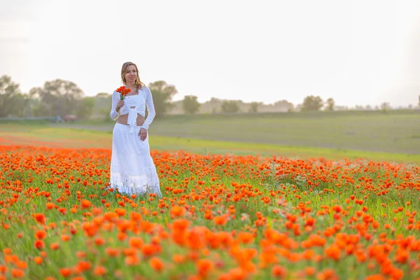 Chica en un vestido blanco en el campo de amapola —  Fotos de Stock