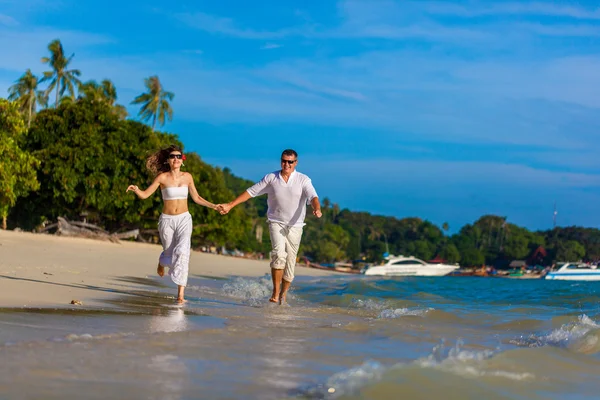 Бегущая пара на тропическом пляже — стоковое фото