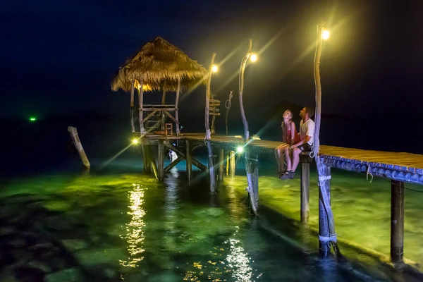 夜のロマンチックな桟橋に愛のカップル — ストック写真
