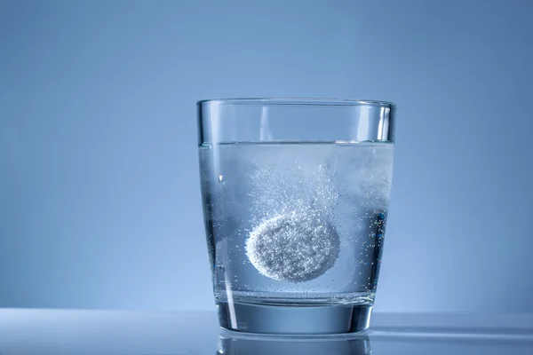 Tabletas efervescentes en un vaso de agua —  Fotos de Stock