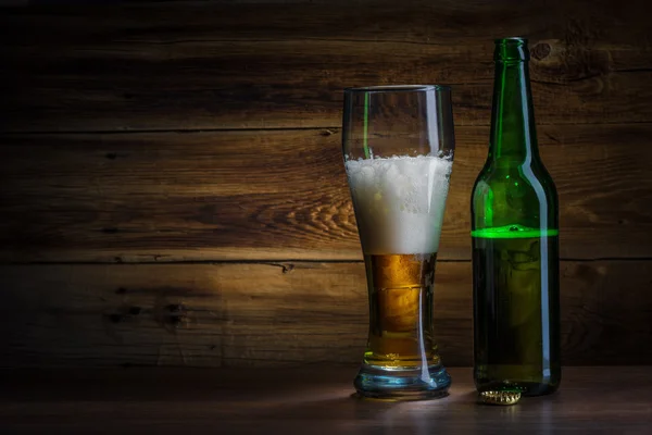 啤酒杯子和瓶子上木制的背景 — 图库照片