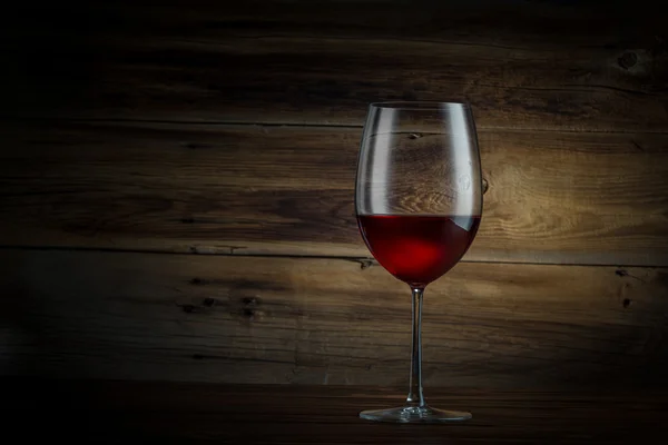 Glas wijn op een houten ondergrond — Stockfoto