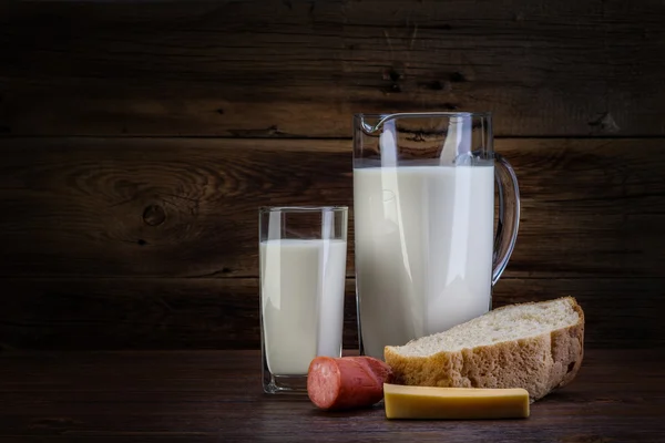 Nature morte con latticini, latte, formaggio su uno schienale di legno — Foto Stock