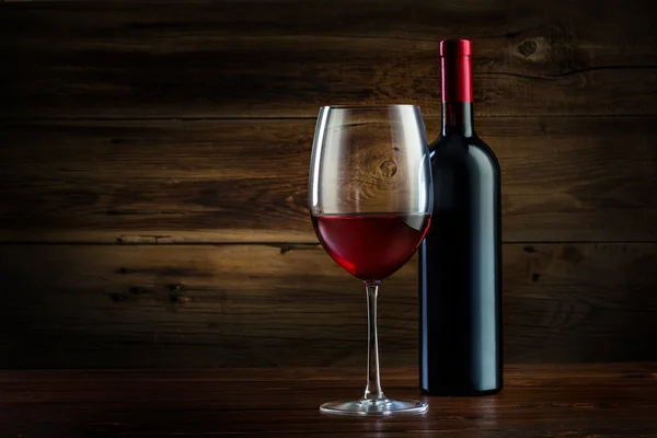 Glass and bottle of wine on a wooden background — Stock Photo, Image