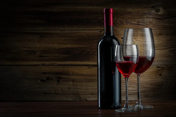 Glass and bottle of wine on a wooden background — Stock Photo, Image
