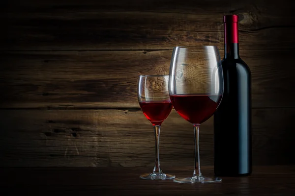 Стакан и бутылка вина на деревянном фоне — стоковое фото
