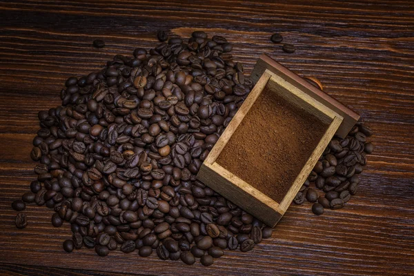 Kaffeebohnen und gemahlen auf Holzgrund — Stockfoto