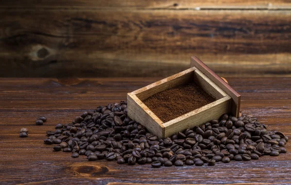 Kaffeebohnen und gemahlen auf Holzgrund — Stockfoto