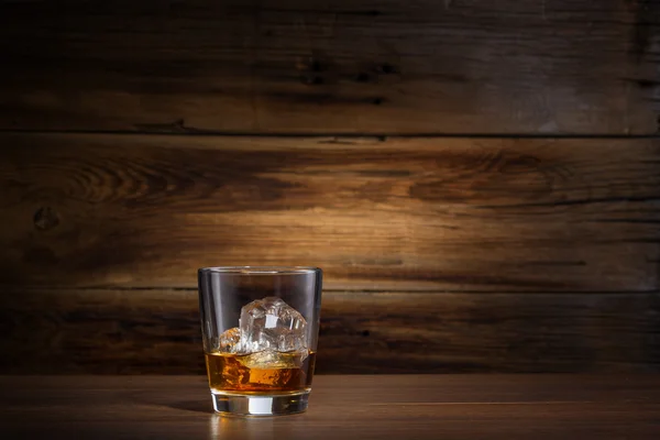 Glas Whisky mit Eis auf Holzgrund — Stockfoto