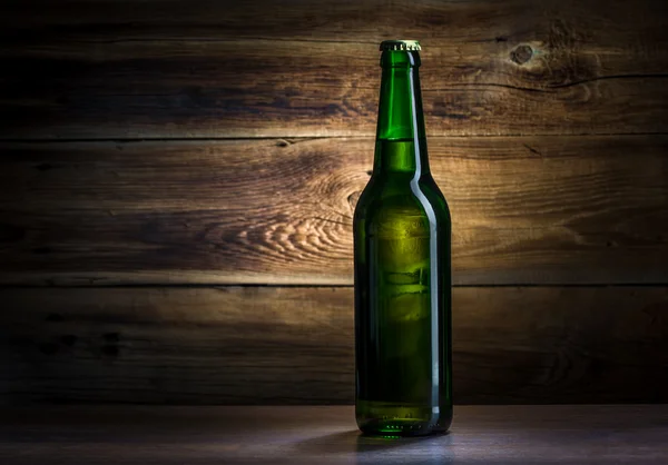 Bottle of beer on a wooden background — Stock Photo, Image