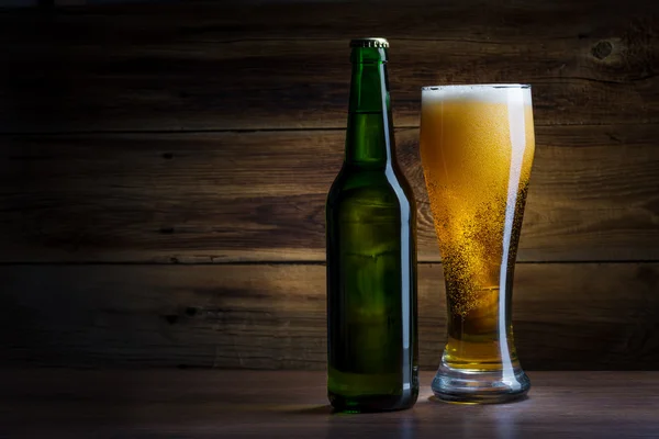 Бутылка пива на деревянном фоне — стоковое фото