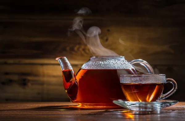 Glass teapot and mug on the wooden background — Stock Photo, Image