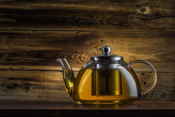 Glas Tekanna med grönt te på en trä bakgrund — Stockfoto