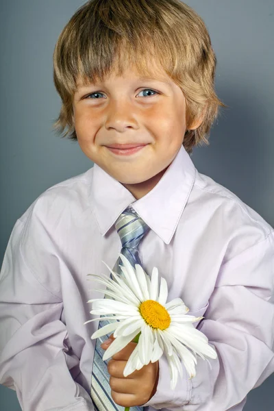 Stilig pojke med blommor i händerna — Stockfoto