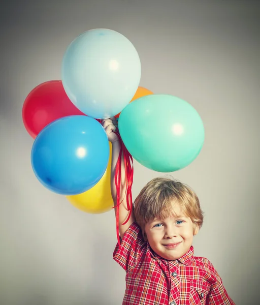 Dreng, der holder ballonerne - Stock-foto