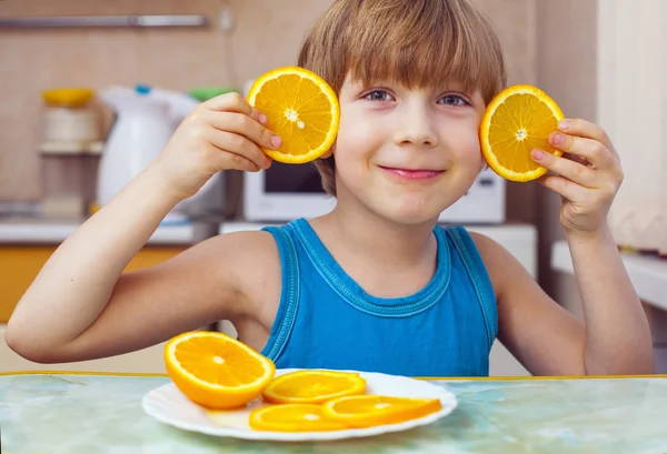 Мальчик ест апельсин — стоковое фото