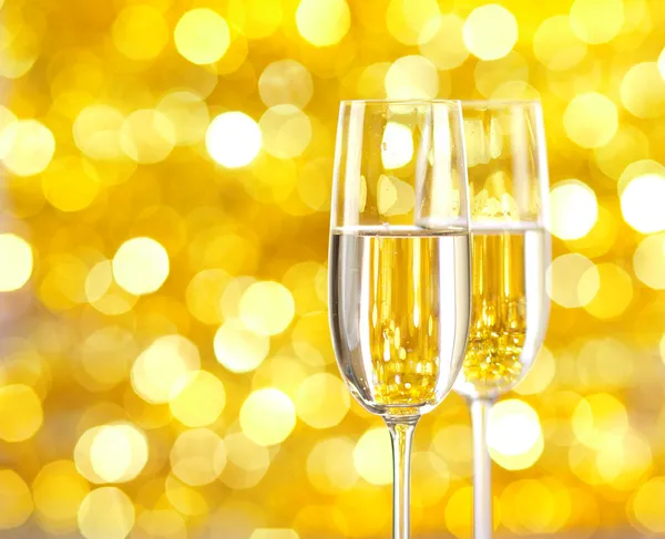 Dvě sklenice šampaňského s osvětlením na pozadí. — Stock fotografie