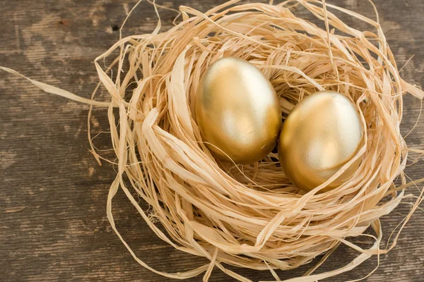 Golden eggs in the straw — Stock Photo, Image