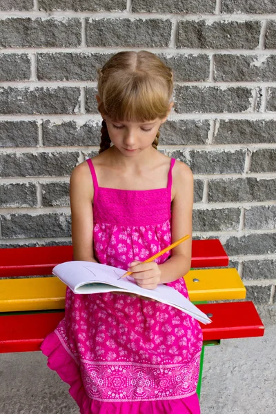 Girl draws on the album sitting bench — Stock Photo, Image